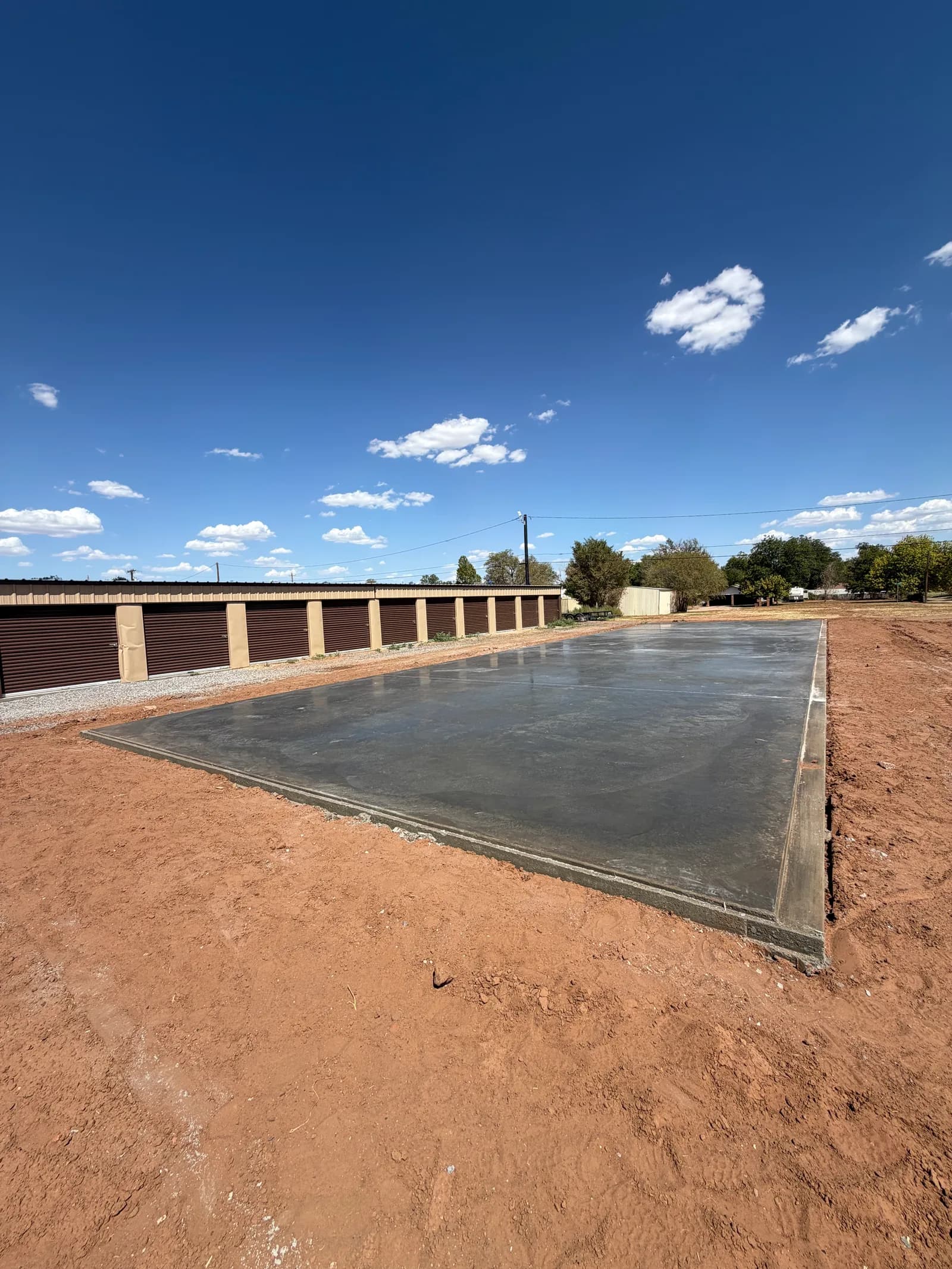 Childress 30' x 100' Storage Building Foundation — completed level slab beside the existing buildings in Childress, TX